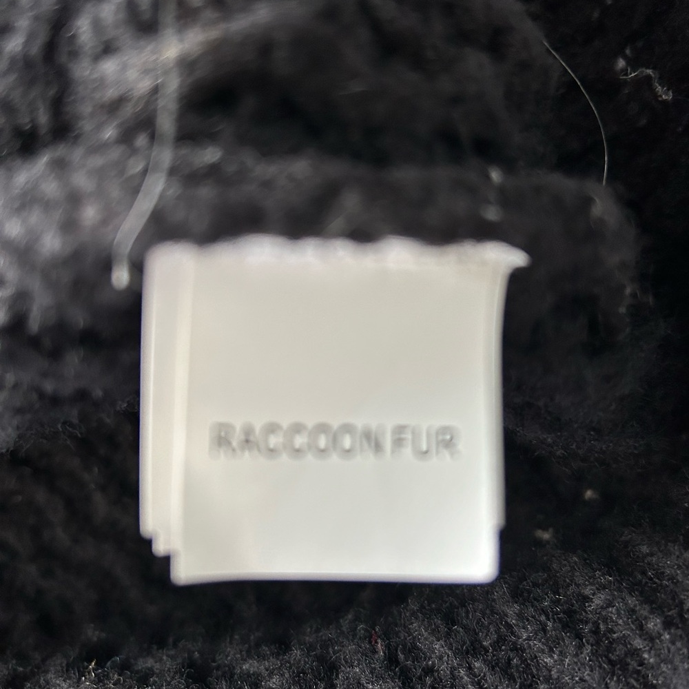 Black knot poncho with raccoon fur around the collar.